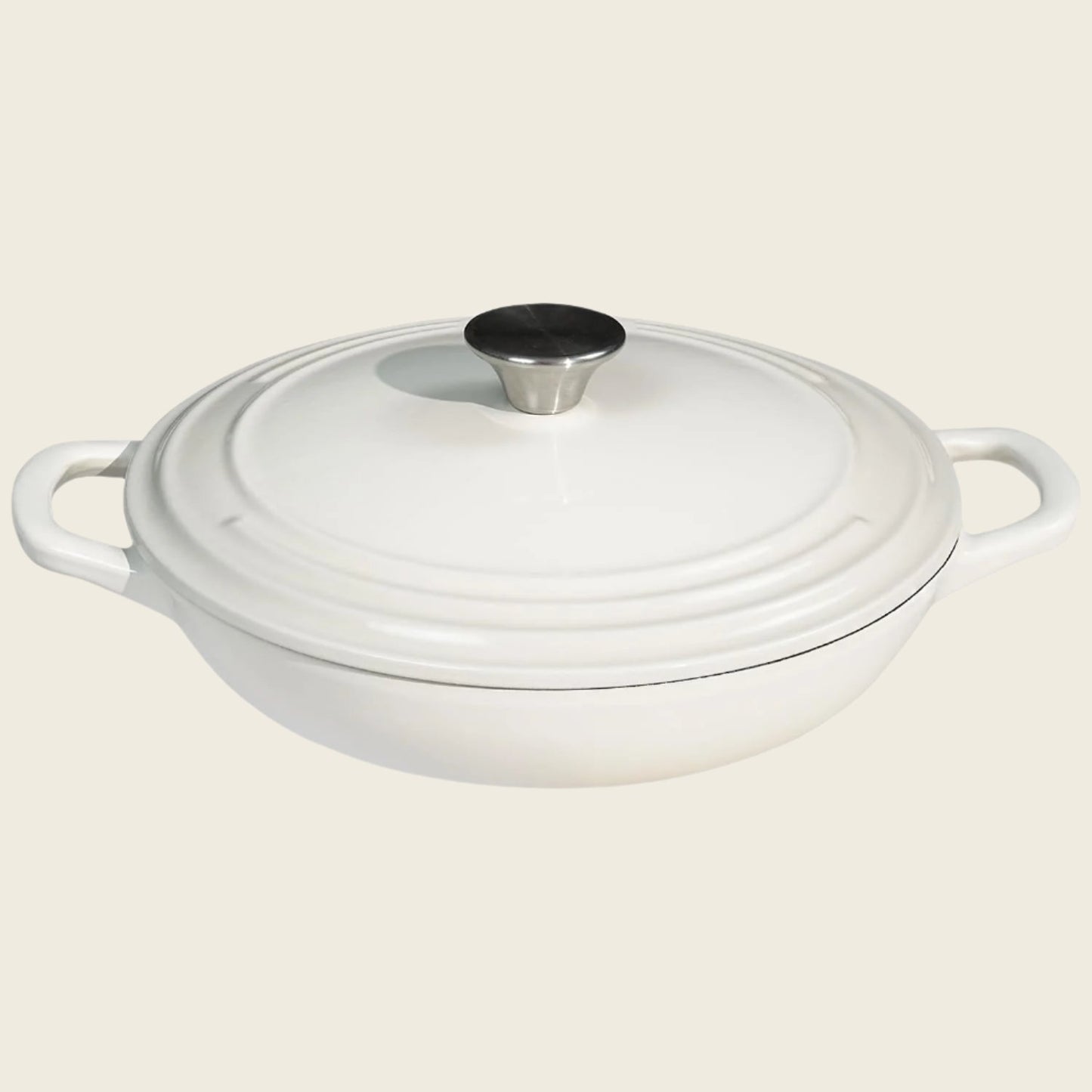 A white enameled cast iron braiser with a lid, featuring a round shape and two handles.