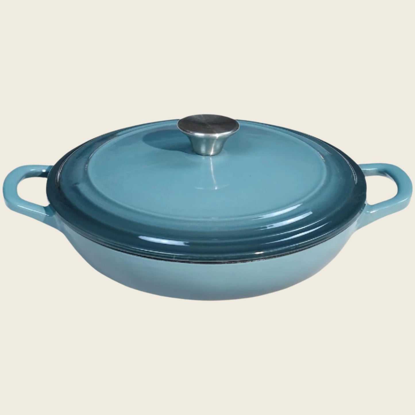 A blue enameled cast iron braiser with a lid, featuring a round shape and two handles.