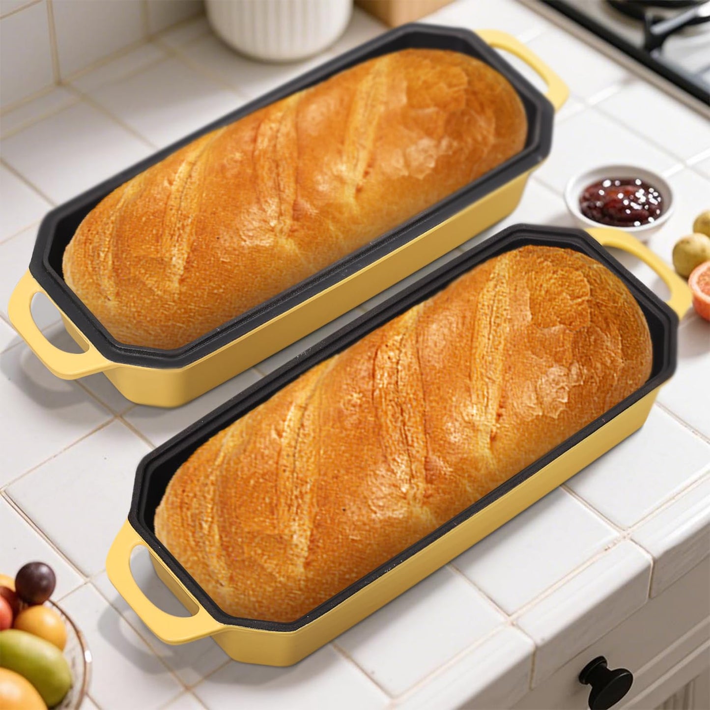 Two loaves of bread in yellow loaf pans on a kitchen counter.