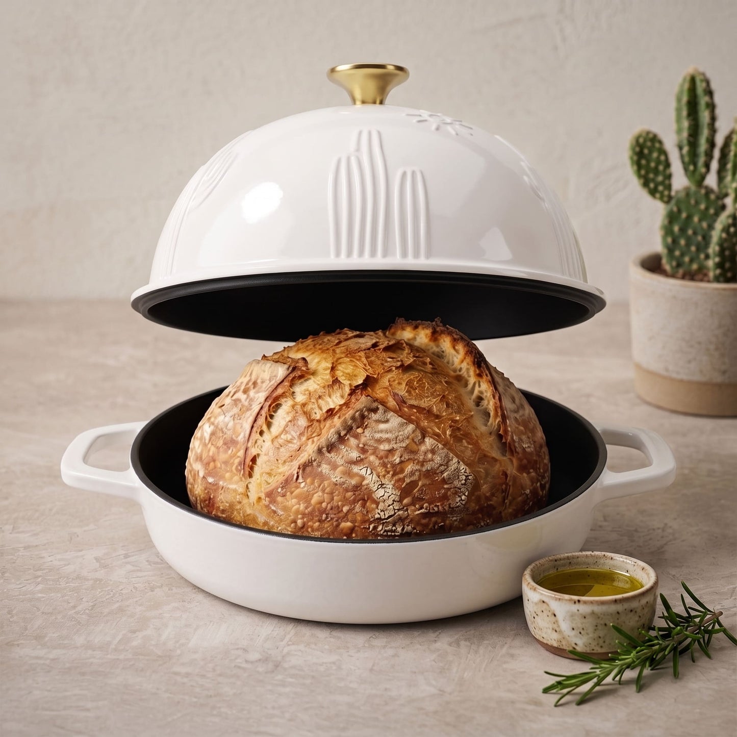 Pearl White cast iron bread oven with domed lid, open base holding rustic loaf, pearl white
