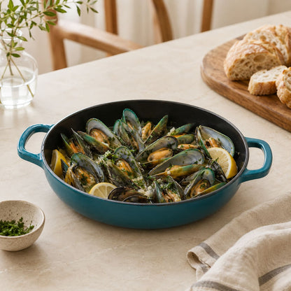 Dark Cyan essential shallow braiser with two handles, filled with mussels and lemon