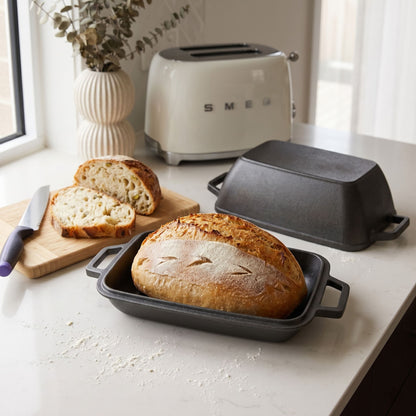 Oval bread oven on kitchen counter with a baked loaf and lid
