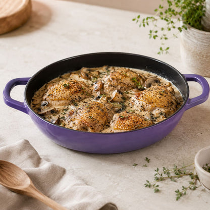 Iris Purple enamel shallow braiser with handles, filled with baked chicken and herbs