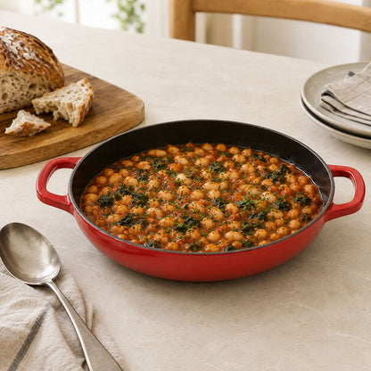 cherry Red enamel shallow braiser with handles, filled with bean and herb casserole