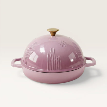 Pink enamel bread oven with gold knob and side handles, embossed decorative pattern.