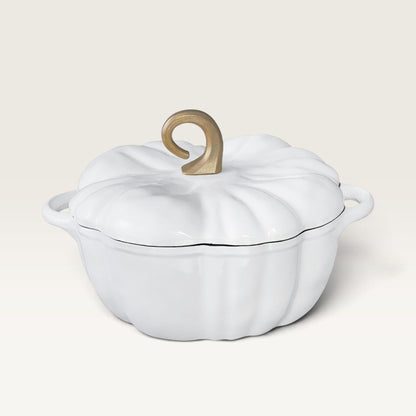 A pearl white enameled cast iron Dutch oven shaped like a pumpkin, featuring a ribbed lid with a decorative gold-colored handle and side handles, set against a solid cream background.