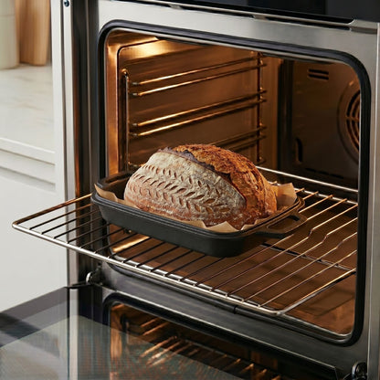 Oval bread oven inside an oven with a baked loaf on the rack